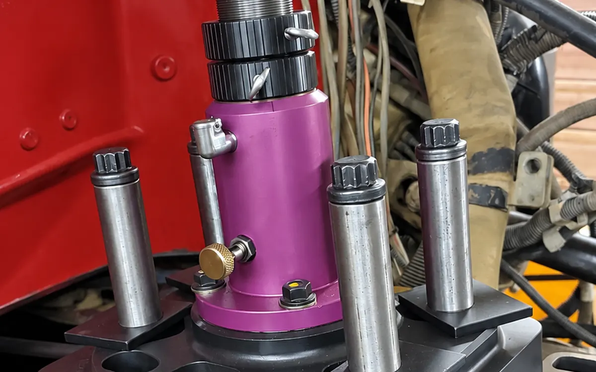 Purple counterbore cutting tool mounted on a diesel engine block with its hold-down studs