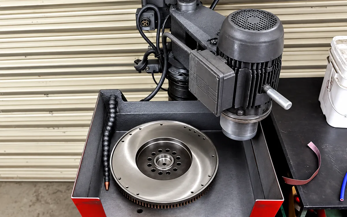 Flywheel set in the resurfacing machine with the grinding head positioned over its friction surface